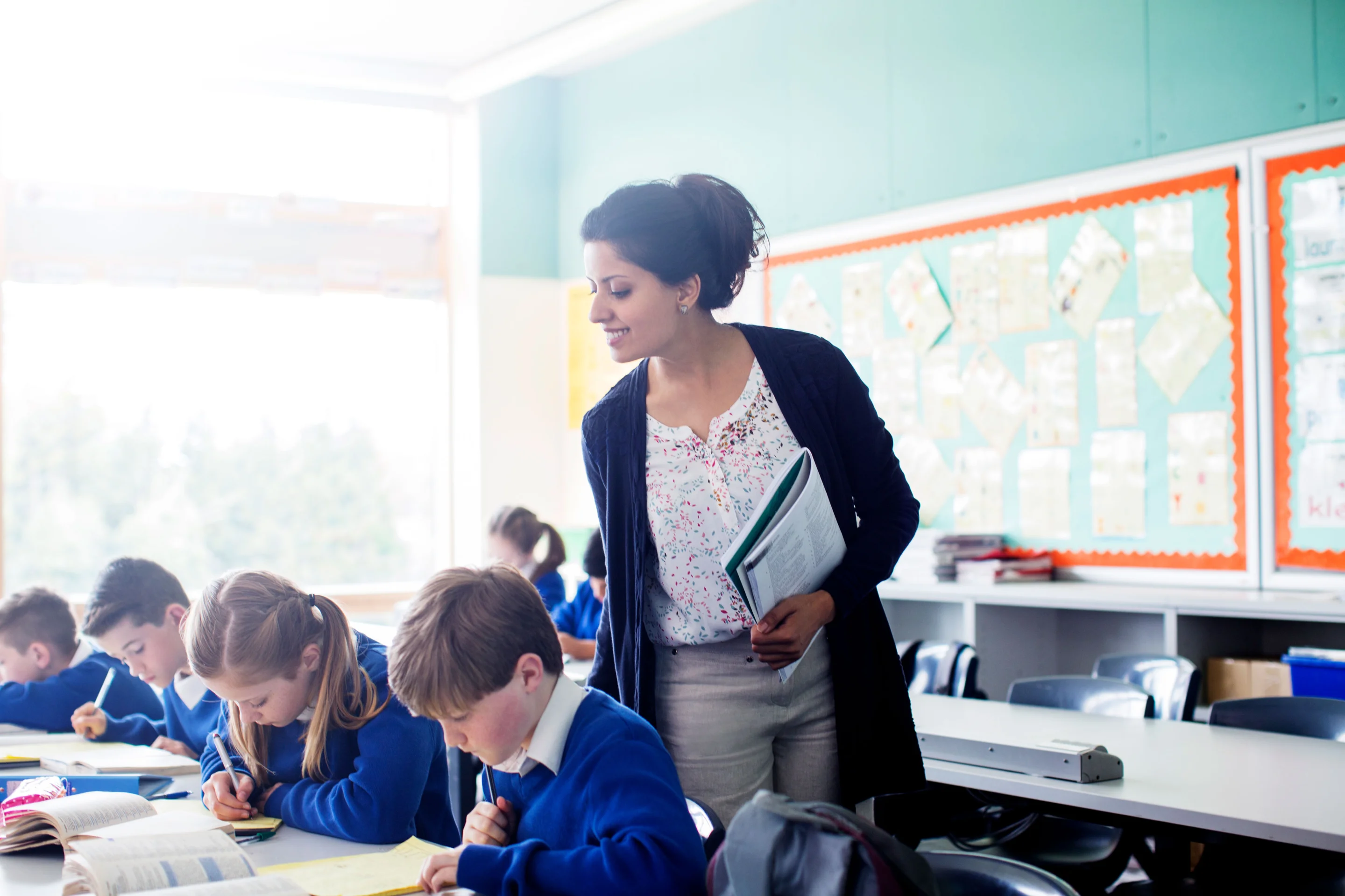 stock-photo-female-teacher-with-her-pupils-in-classroom-156616281.webp
